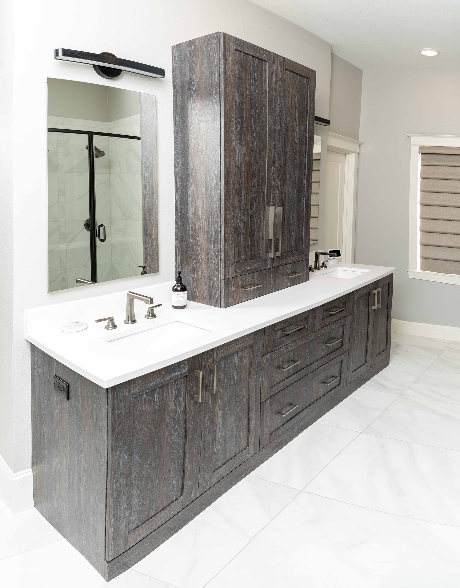 A bathroom with a sink , mirror , cabinets and drawers.