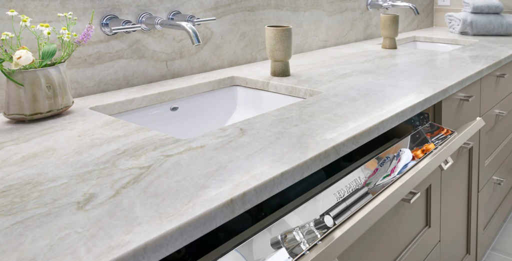 A bathroom counter with two sinks and a dishwasher