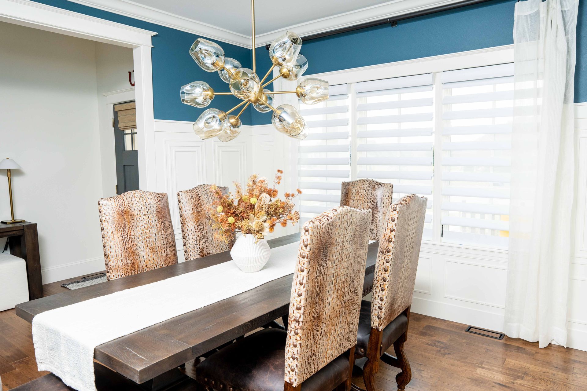 A dining room with a table and chairs and a chandelier.