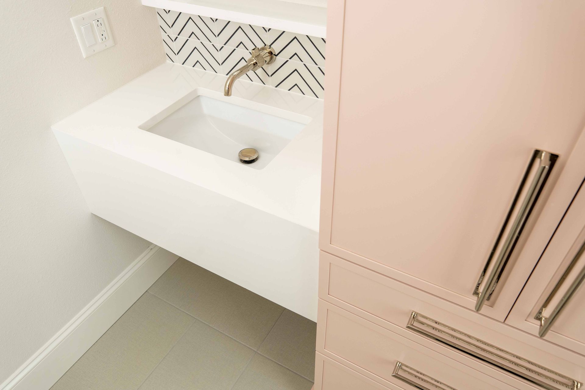 A bathroom with a sink , cabinets and drawers.