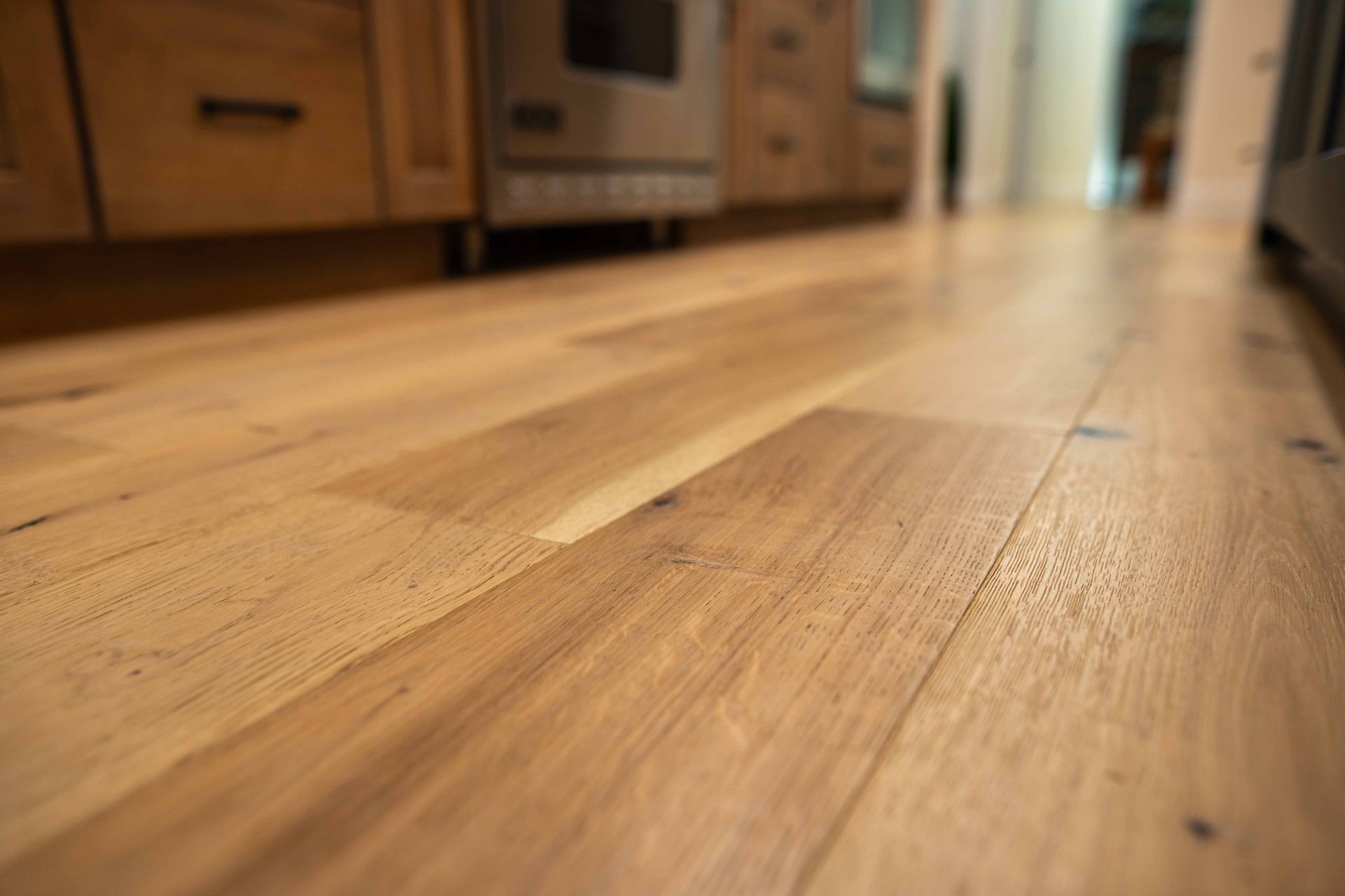 A close up of a wooden floor in a kitchen.