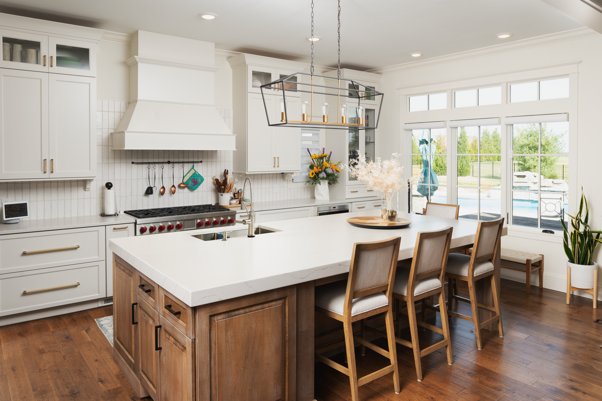 A kitchen with a large island and white counter tops.