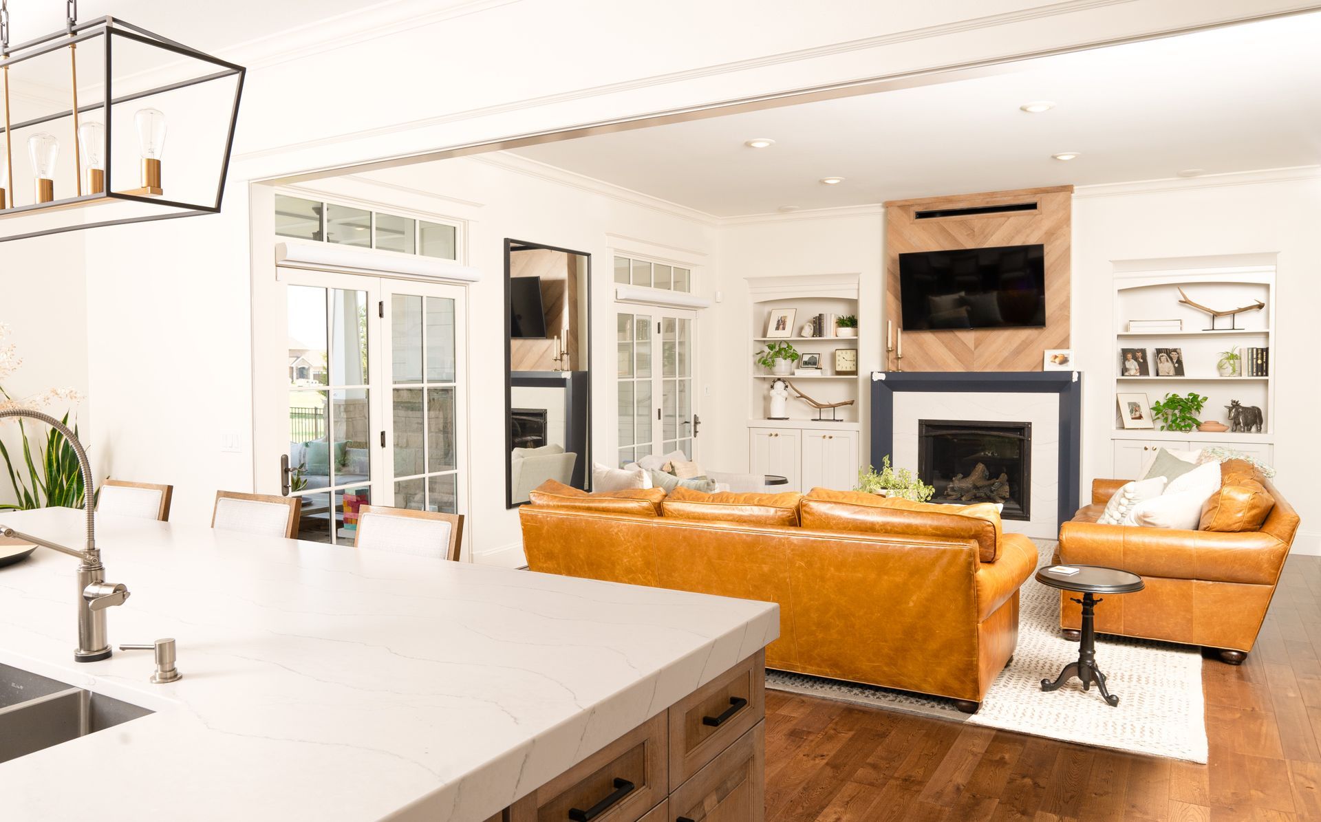 A living room with a couch , chair , fireplace and television.