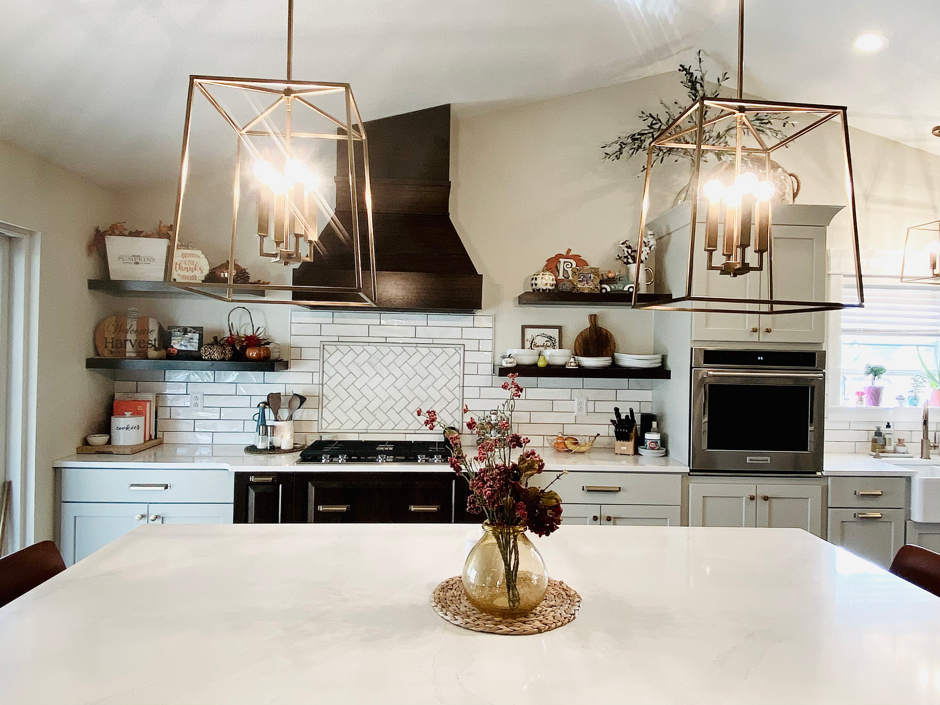 A kitchen with a vase of flowers on the counter.