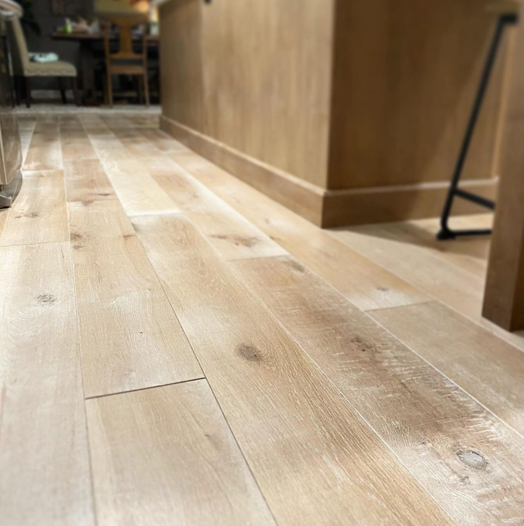 A close up of a wooden floor in a kitchen.