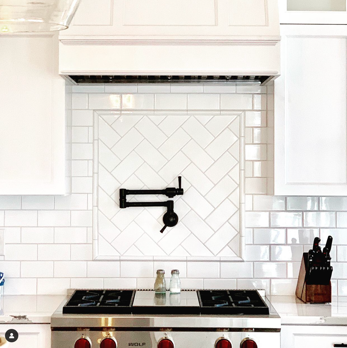 A kitchen with a stove top oven and a faucet on the wall