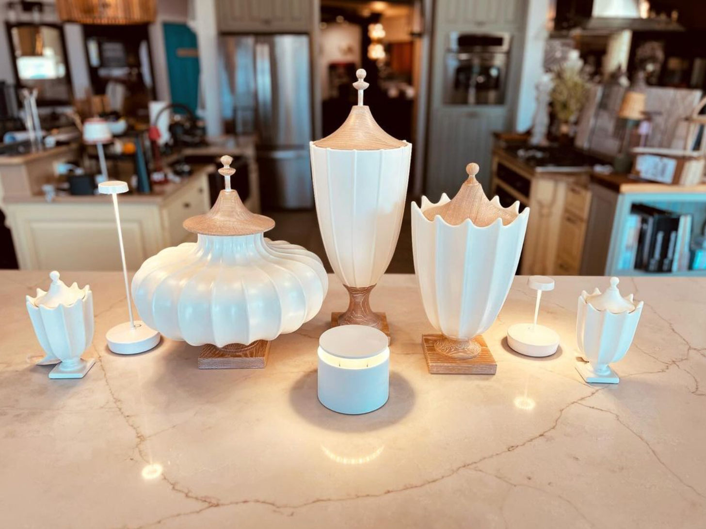 A group of white vases are sitting on top of a counter.