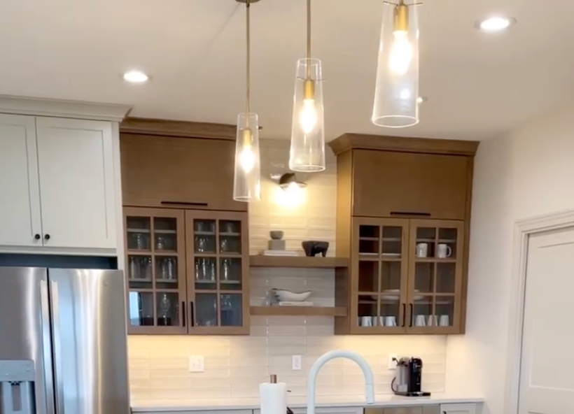 A kitchen with stainless steel appliances and glass cabinets