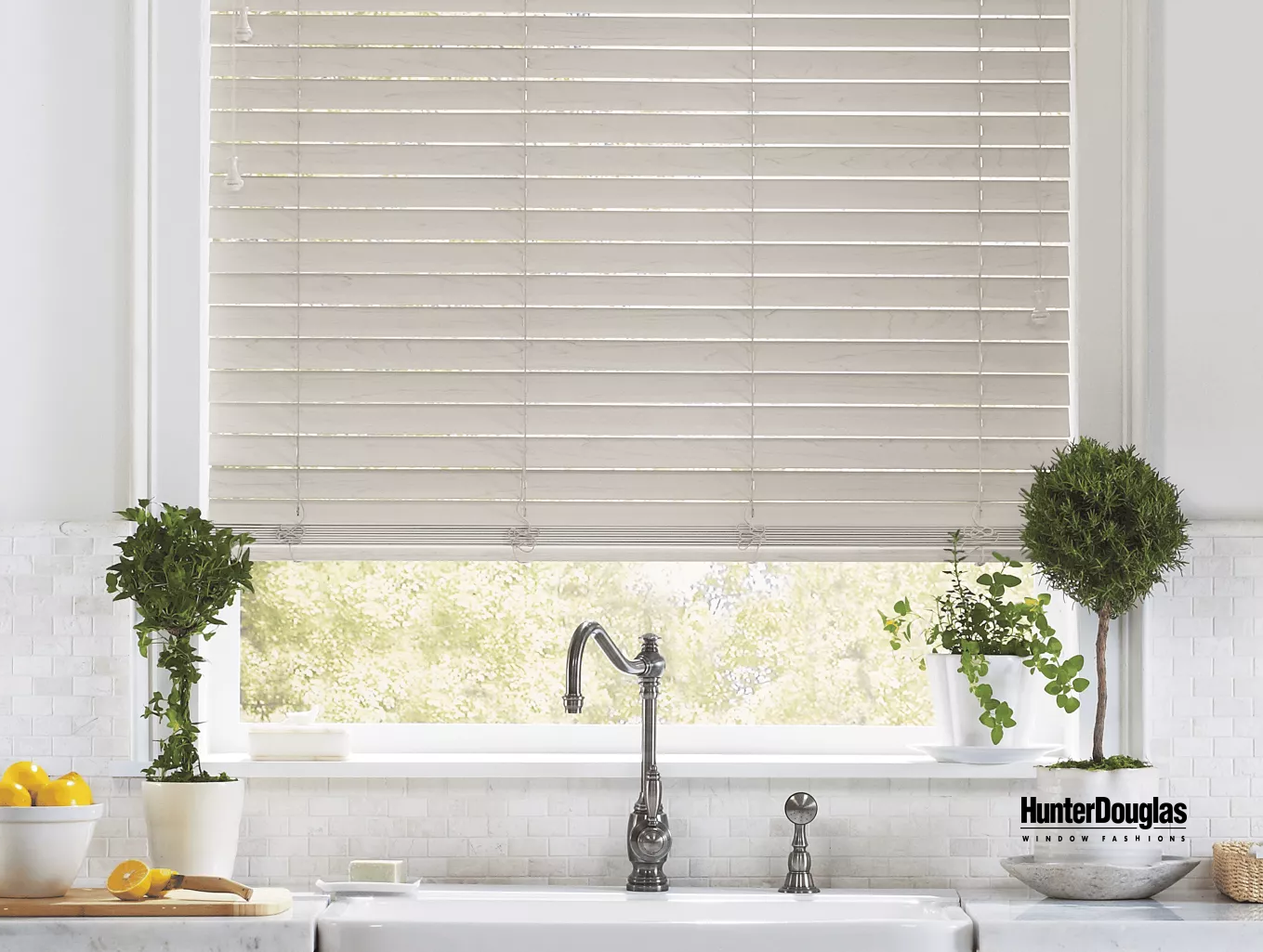 A kitchen with a sink and a window with blinds.