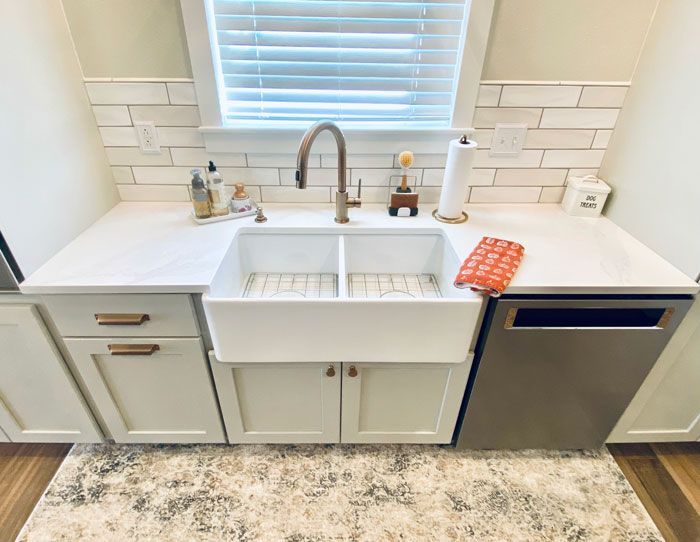 A kitchen with a sink and a window with blinds