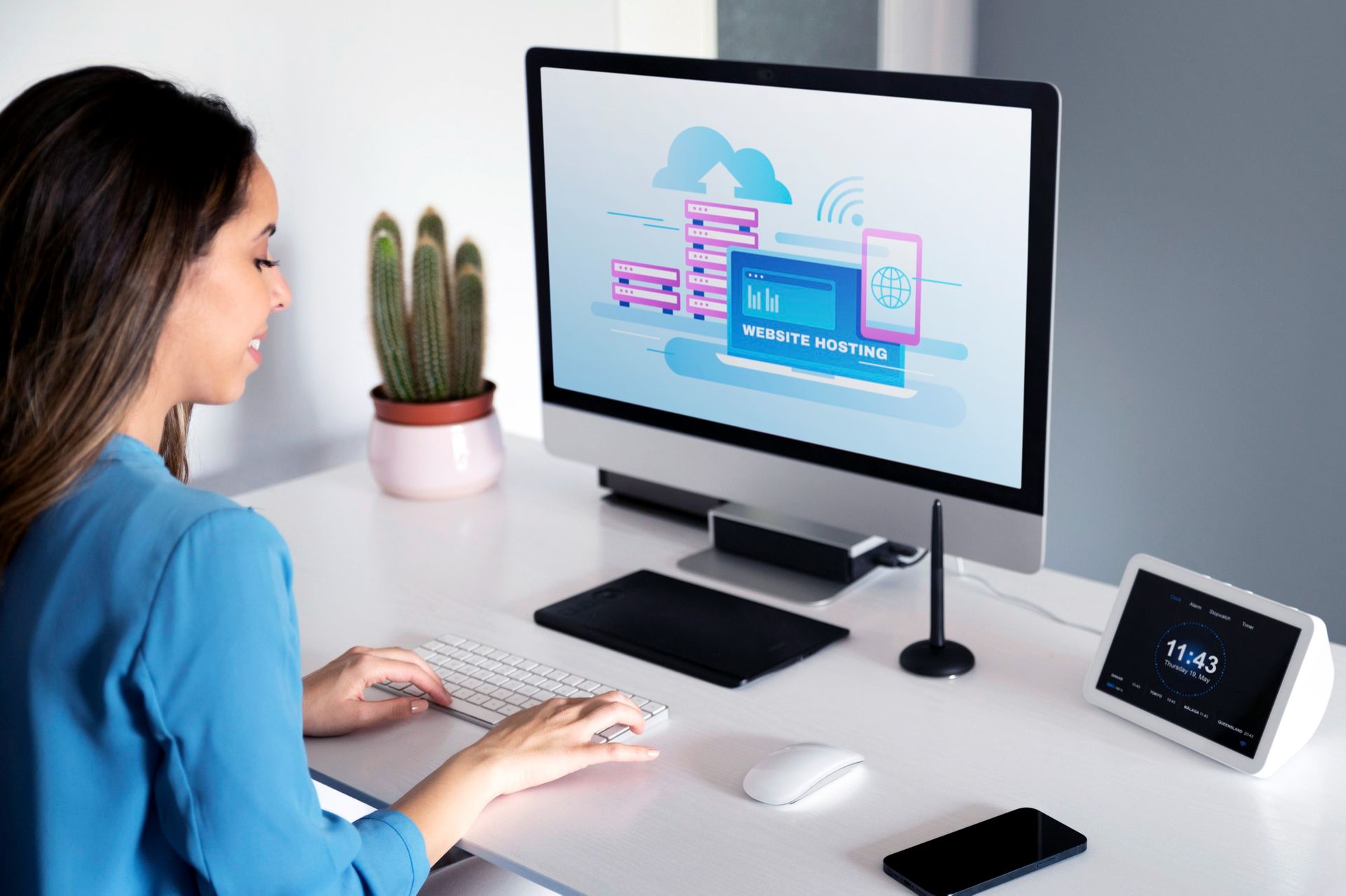 A woman is sitting at a desk using a computer.