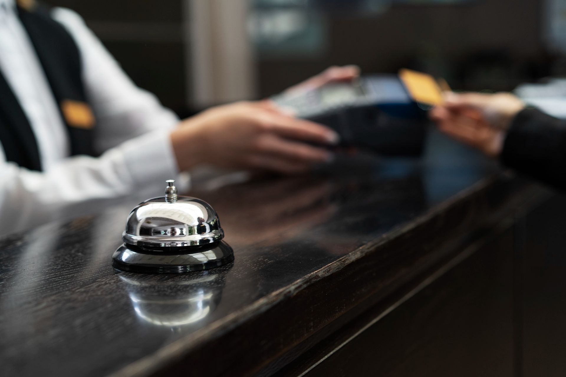 A person is giving a credit card to a hotel receptionist.