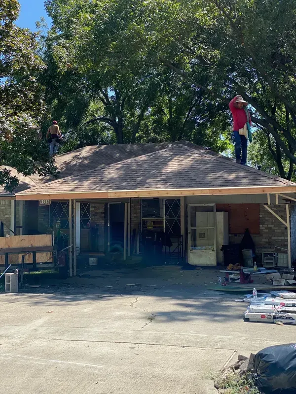 A man is standing on the roof of a house.