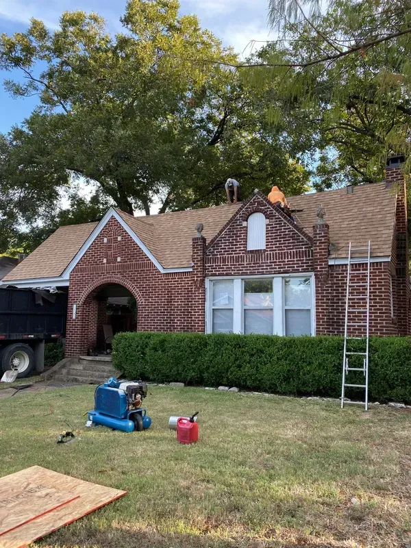 A brick house is being remodeled with a new roof.