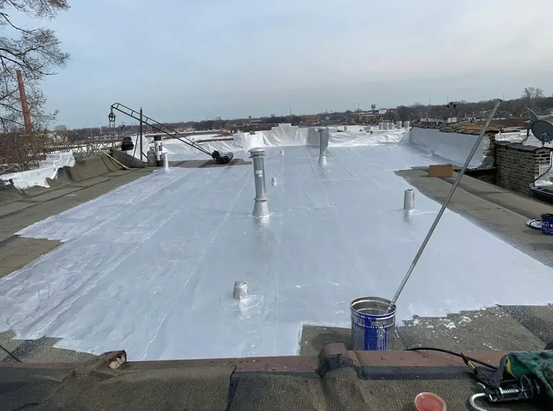 The roof of a building is being painted white.