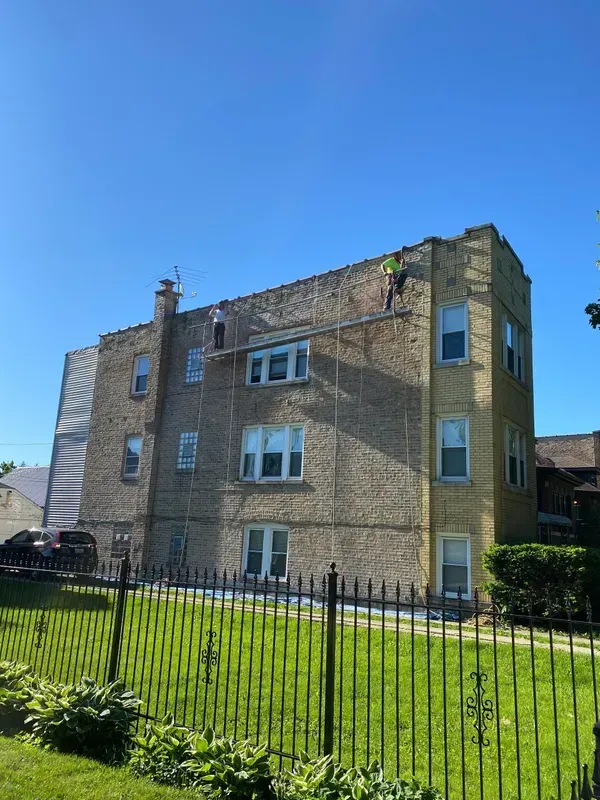 A man is standing on a scaffolding on the side of a building.
