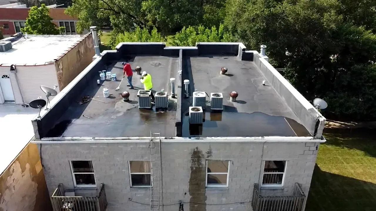 A man is standing on a scaffolding on the side of a building.