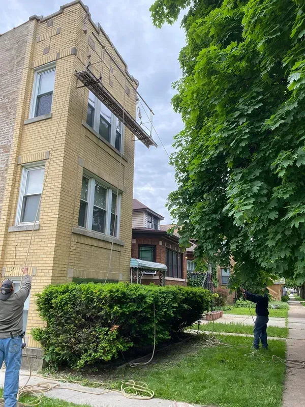 A man is standing in front of a large brick building.
