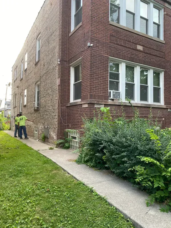 A group of people are standing in front of a large brick building.