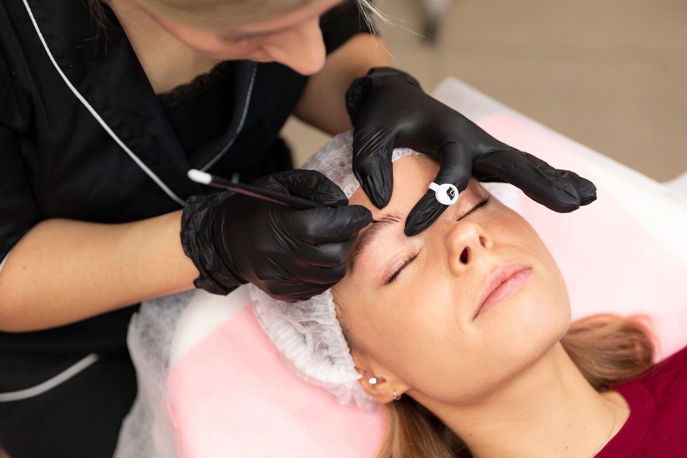 Eine Frau lässt sich in einem Schönheitssalon die Augenbrauen tätowieren.