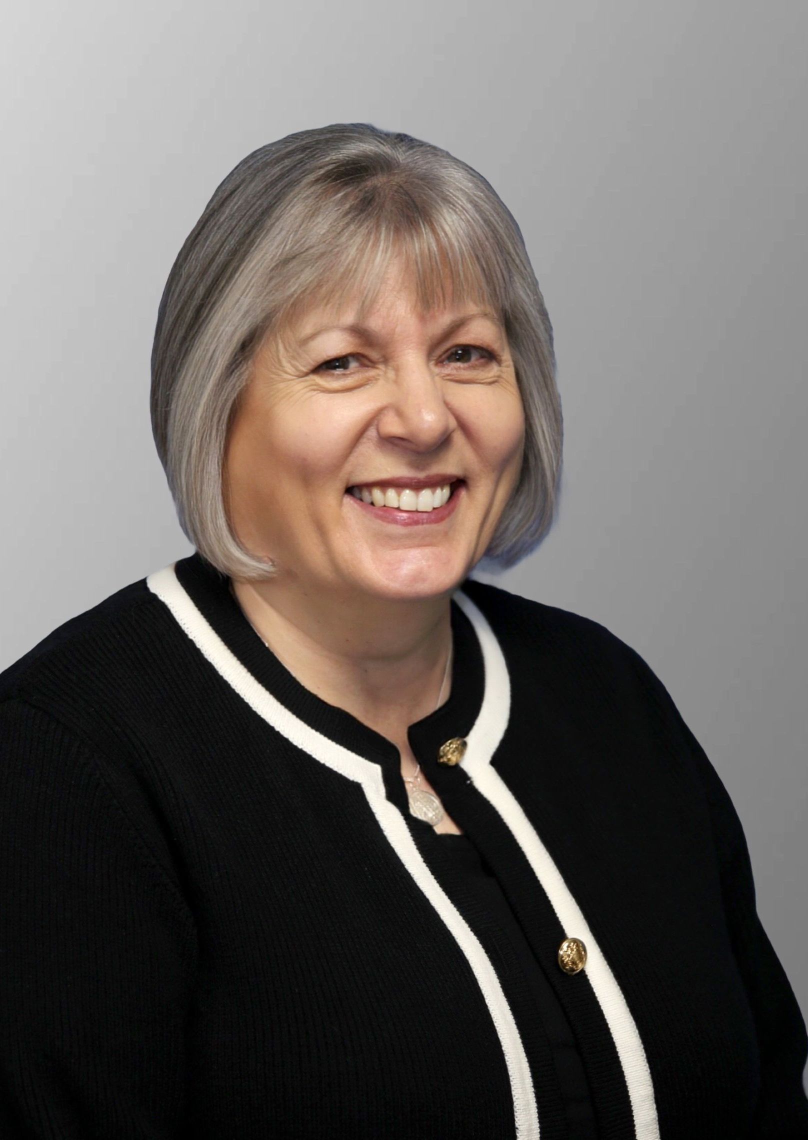 A woman in a black and white striped shirt is smiling for the camera.