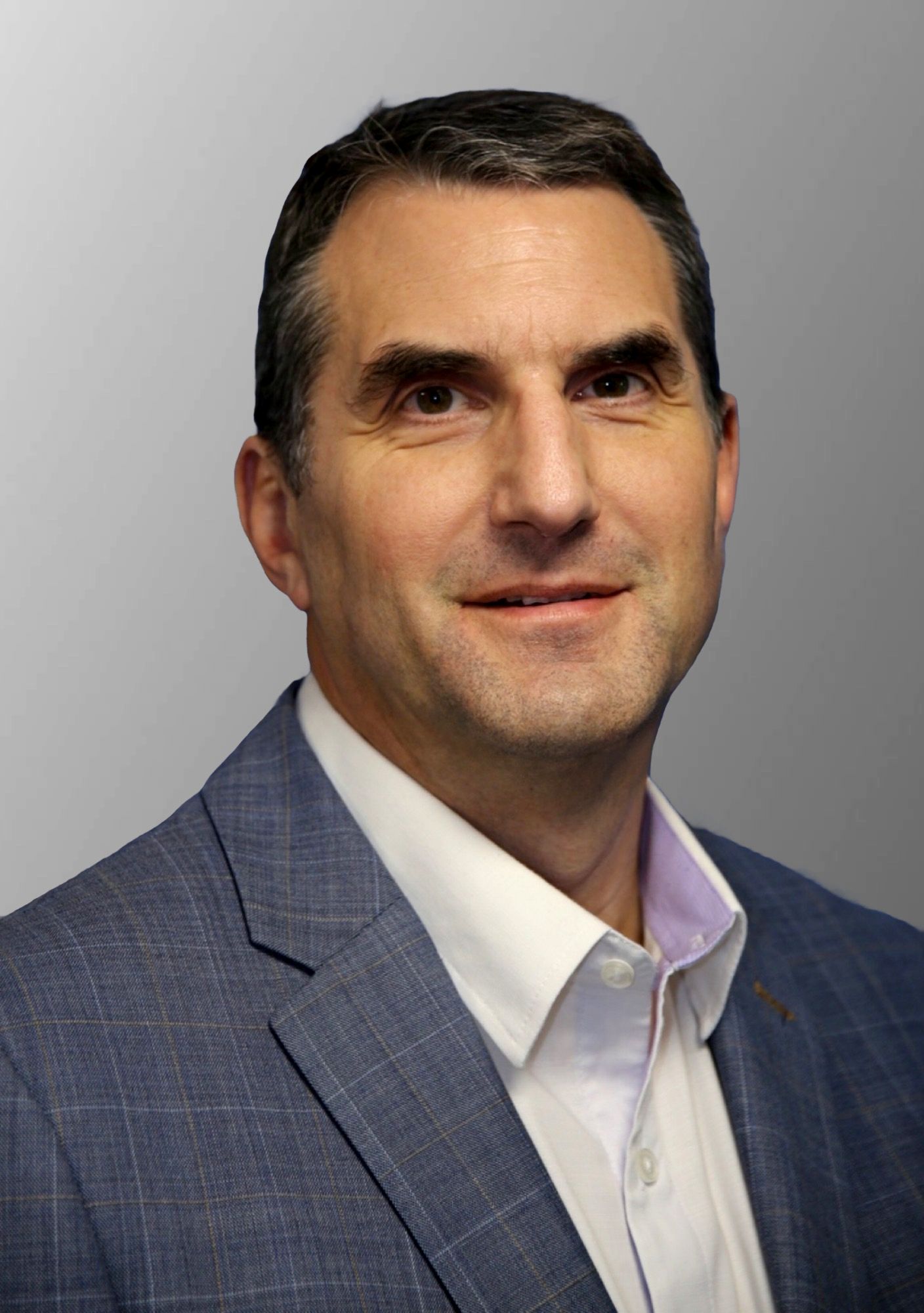 A man in a suit and tie is standing in front of a yellow van.