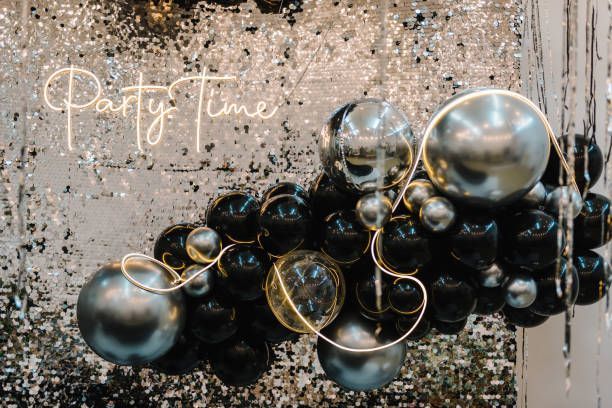 Elegant black and silver photo booth backdrop with balloons.