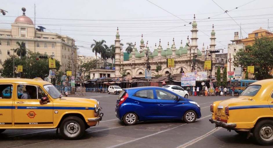 gelbe alte Taxis im Kalkutta, im Hintergrund die Tipu Sultan Moschee