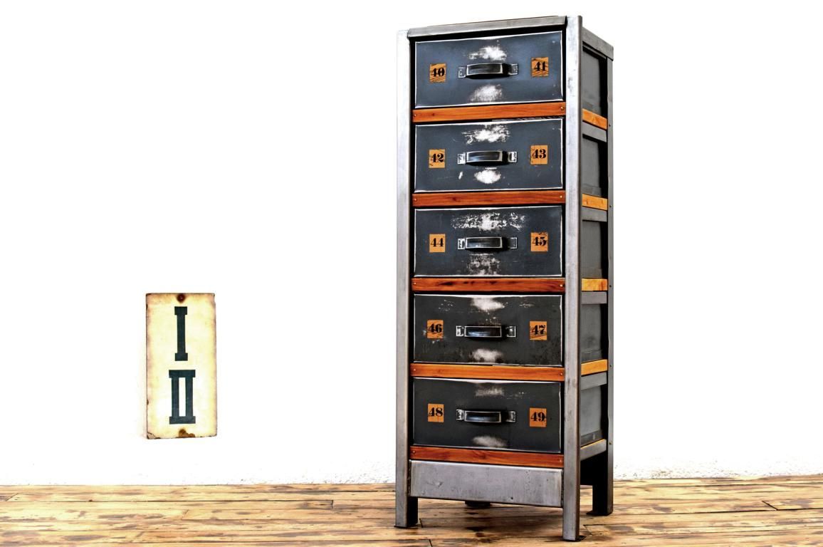 alter Schubladenschrank aus Metall in dem Holz als dekoratives Element eingesetzt ist