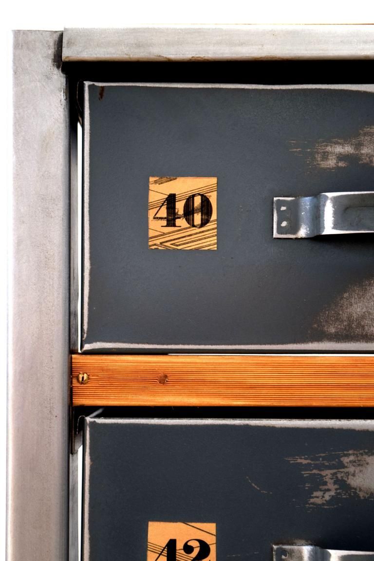 Front eines antiken Schubladenschrankes aus Metall mit einer  Dekorelementen aus Holz