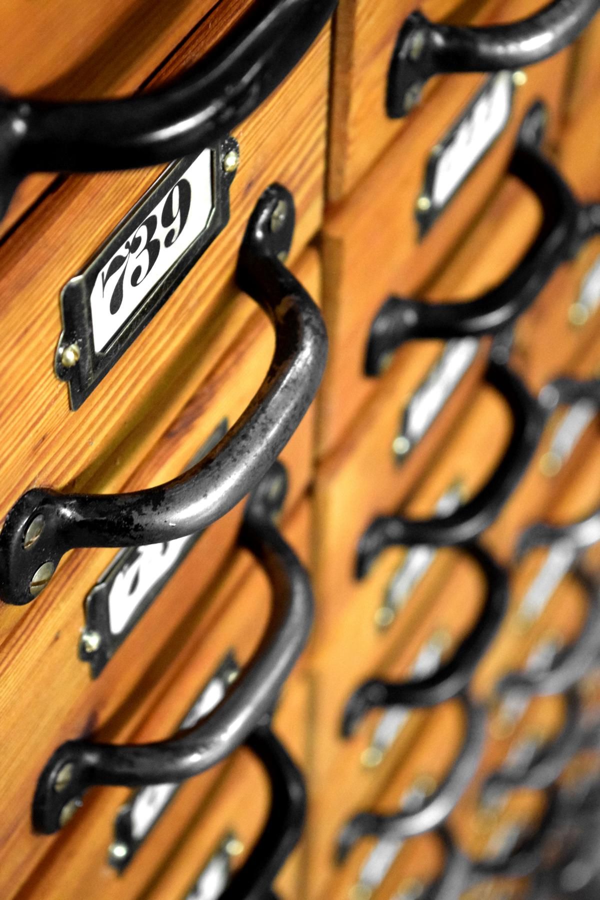 Griffe und Beschriftungsfelder aus Metall auf antiken Schubladen