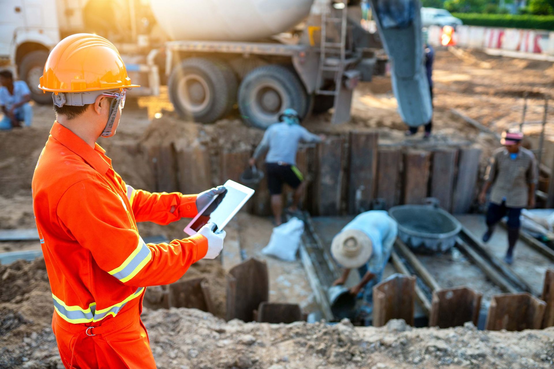Engineers inspect the pouring of concrete with tablet.