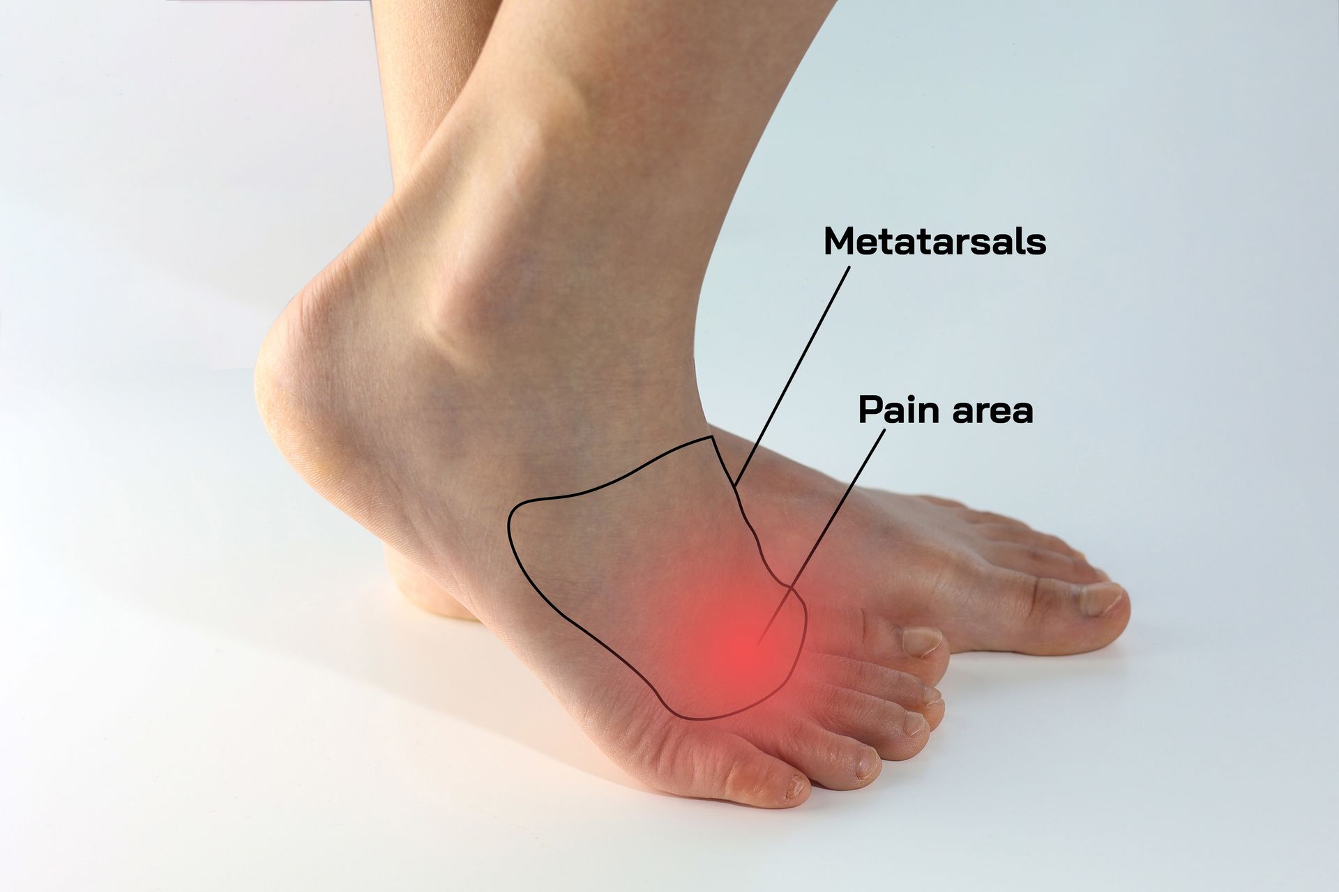 A woman is sitting on a couch holding her foot in pain.