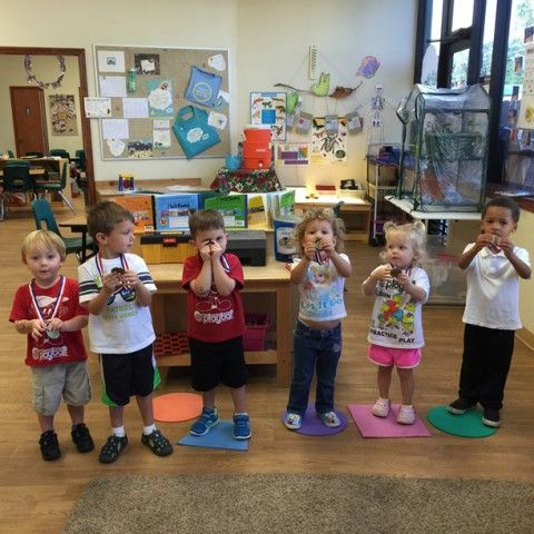 A group of children standing in a classroom with medals around their necks