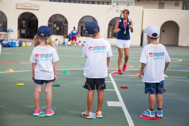 A group of children wearing pepsi shirts are standing on a court