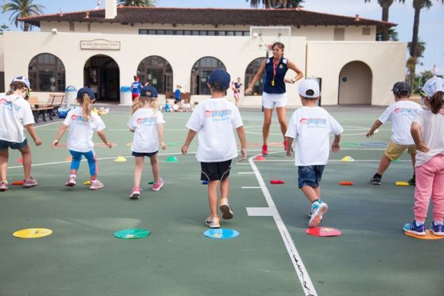 A group of children are playing a game on a court.