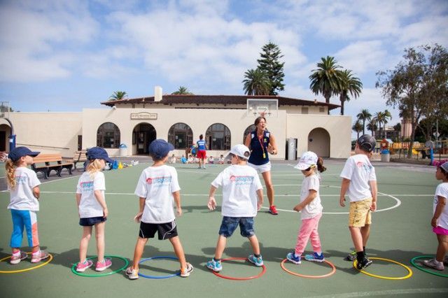 A group of children are playing a game on a court.