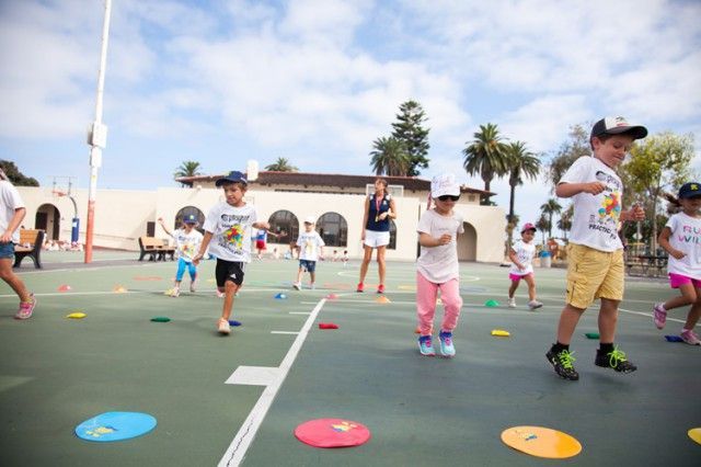 A group of children are playing a game on a court.