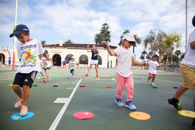 A group of children are playing a game on a court.