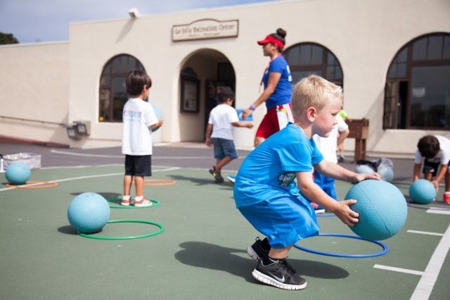A group of children are playing with blue balls on a court