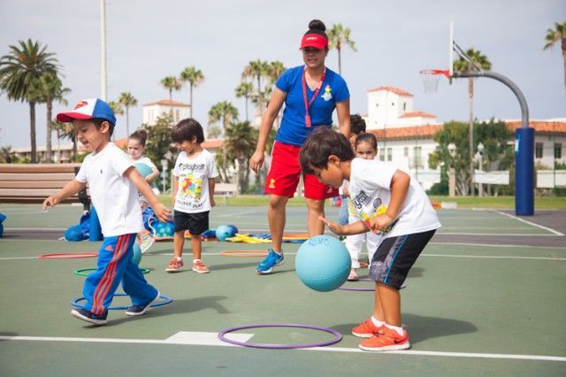 A group of children are playing with a ball on a court.