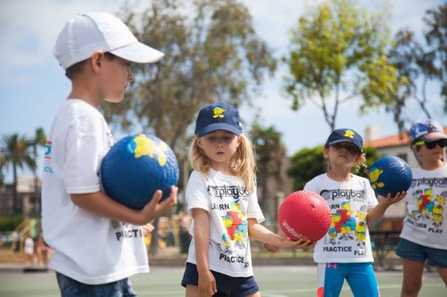 A group of children are holding balls in their hands.