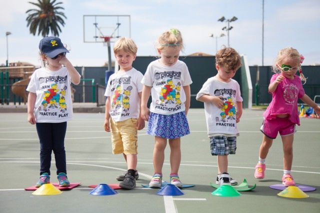 A group of children are playing with cones on a court.