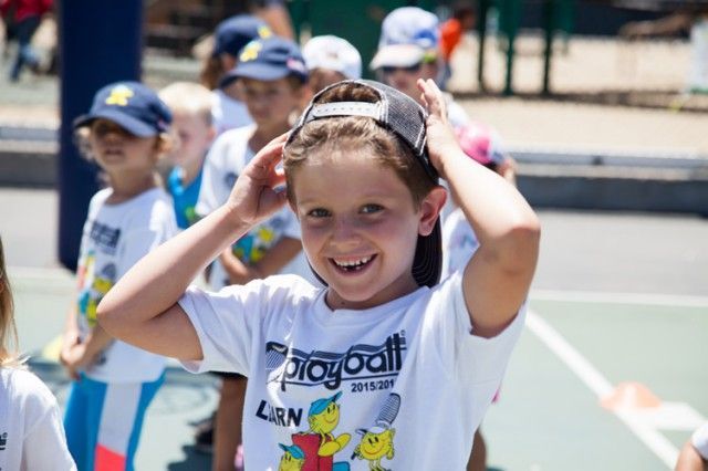 A boy wearing a shirt that says playball on it