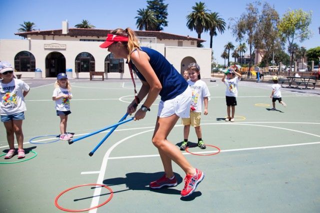 A woman is holding a stick on a basketball court