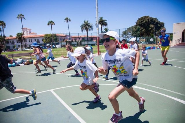 A group of children are running on a basketball court.