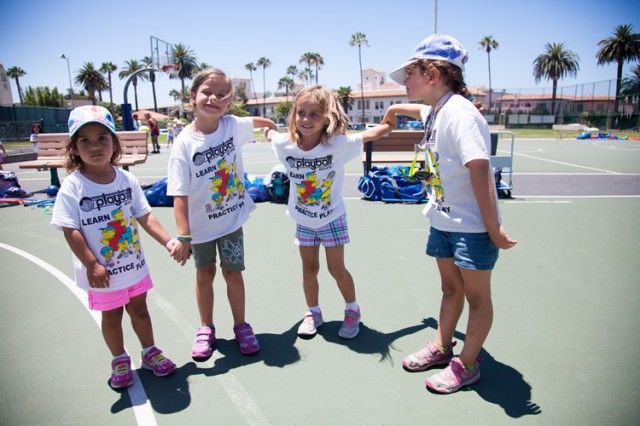 A group of young girls are standing on a basketball court holding hands
