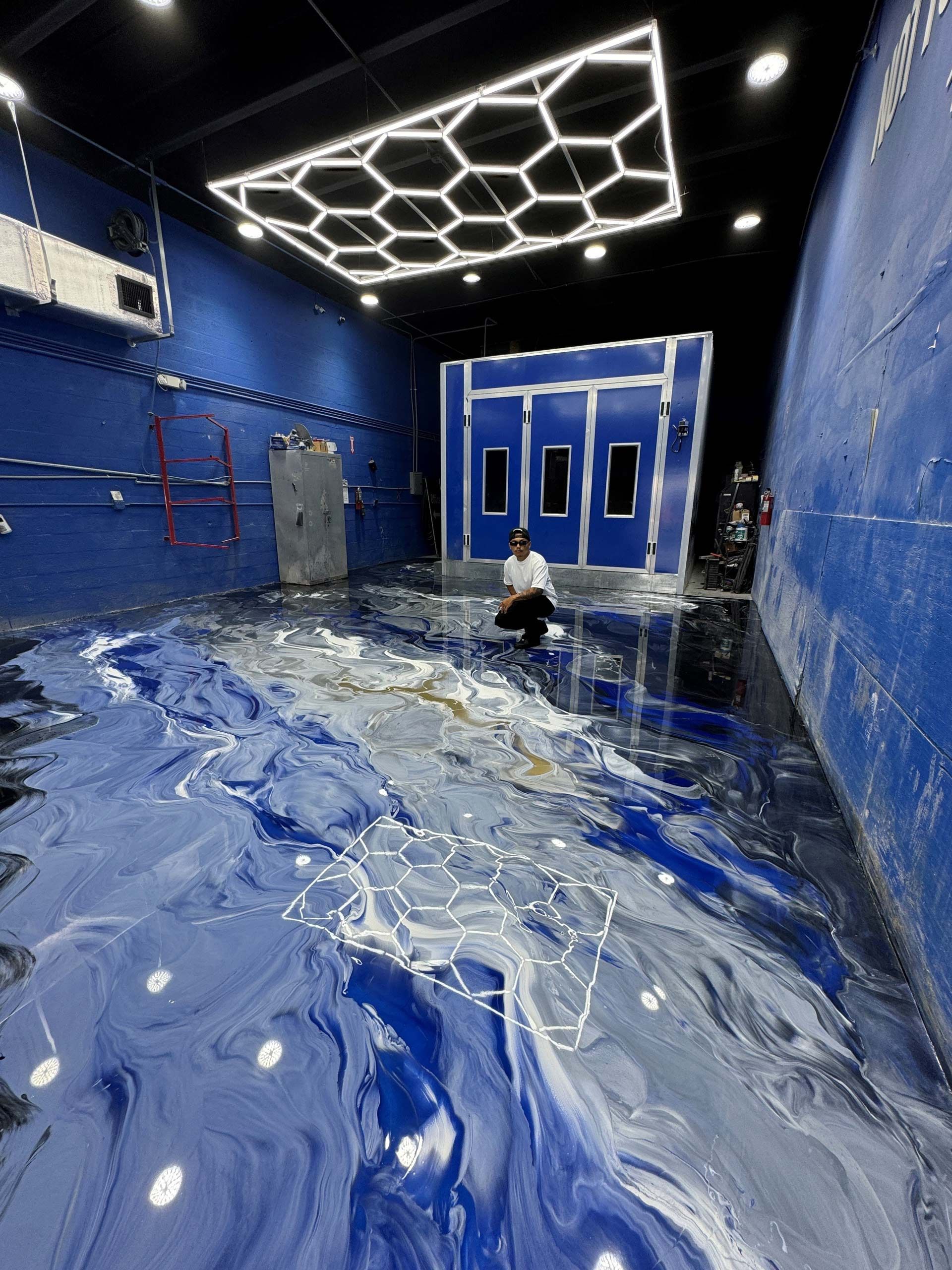 A Man Is Sitting on A Blue Floor in A Room — Honolulu, HI — Maneja Resin Epoxy