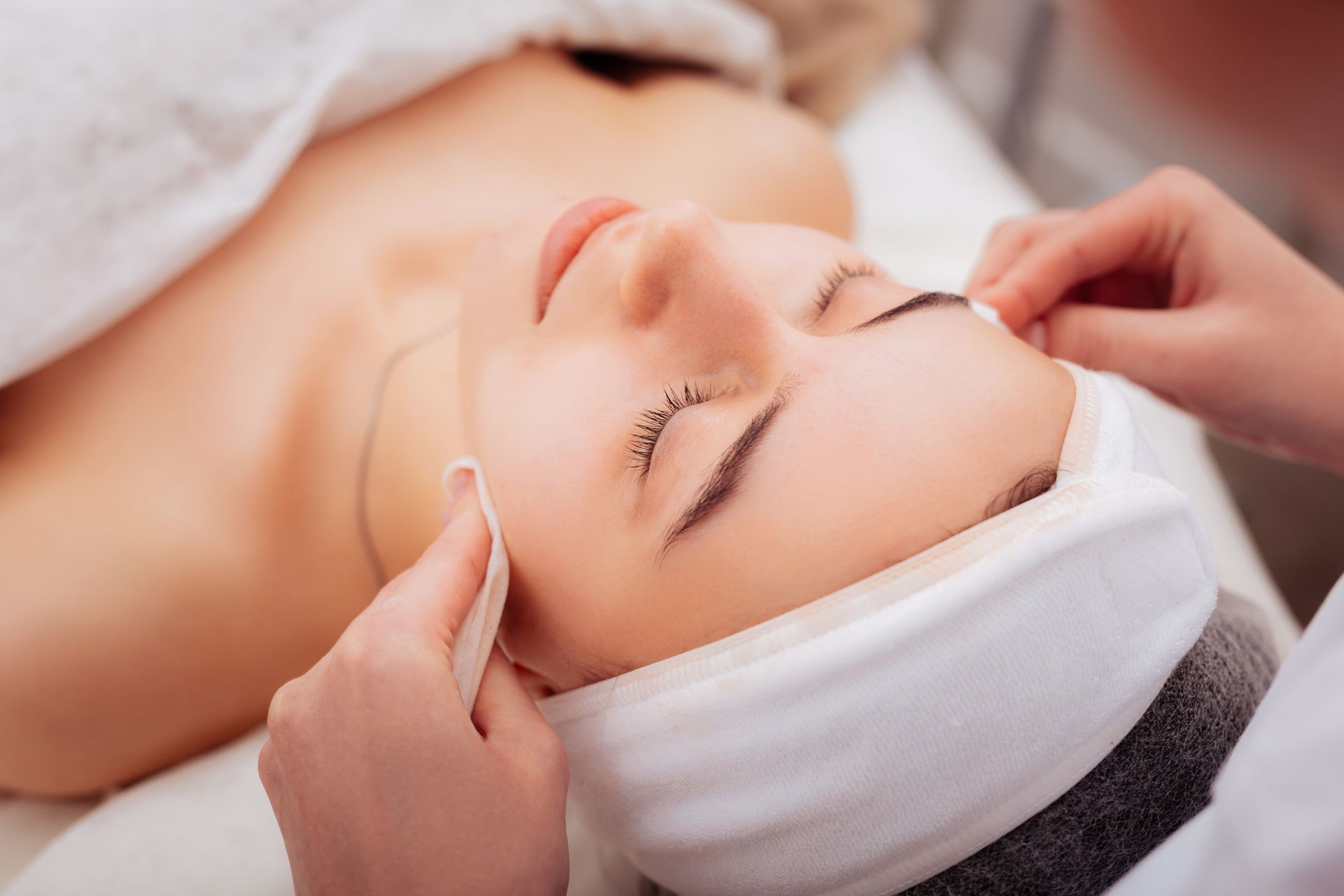 A woman is getting a facial treatment at a spa.