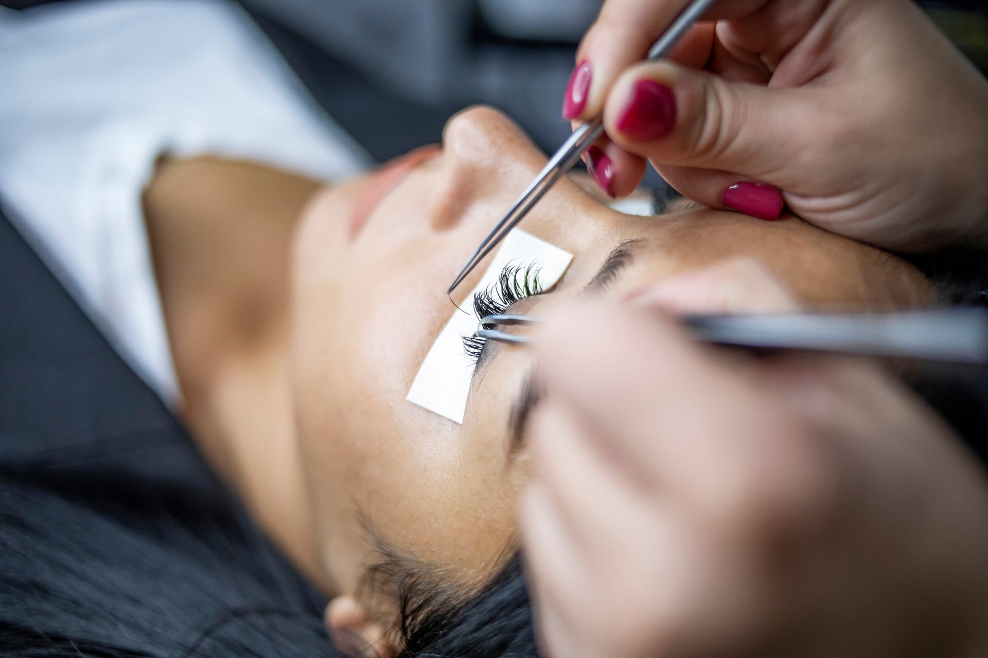 A woman is getting her eyelashes done at a beauty salon.